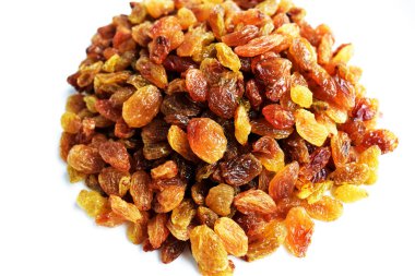 Beyaz arka planda izole edilmiş sarı ve kahverengi kuru üzüm yığınları. Güneşli ve parlak.