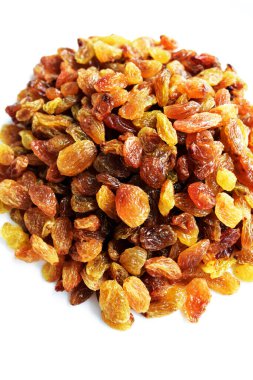 Beyaz arka planda izole edilmiş sarı ve kahverengi kuru üzüm yığınları. Güneşli ve parlak.