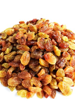 Beyaz arka planda izole edilmiş sarı ve kahverengi kuru üzüm yığınları. Güneşli ve parlak.