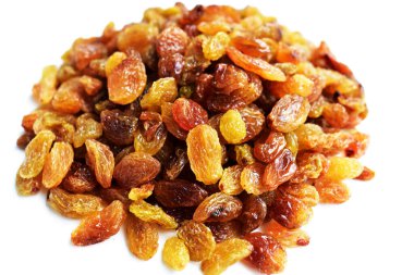 Beyaz arka planda izole edilmiş sarı ve kahverengi kuru üzüm yığınları. Güneşli ve parlak.