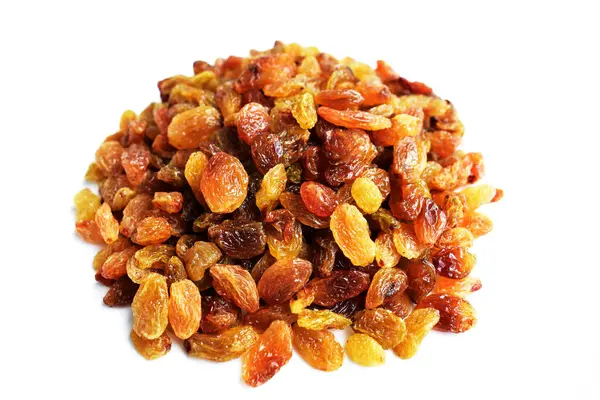 Beyaz arka planda izole edilmiş sarı ve kahverengi kuru üzüm yığınları. Güneşli ve parlak.