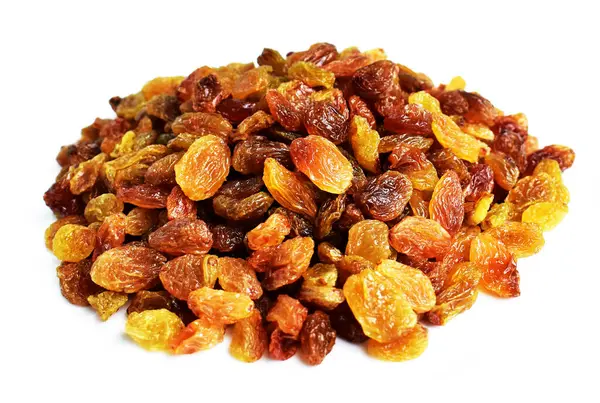 Beyaz arka planda izole edilmiş sarı ve kahverengi kuru üzüm yığınları. Güneşli ve parlak.