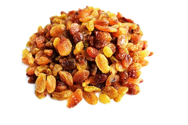 Beyaz arka planda izole edilmiş sarı ve kahverengi kuru üzüm yığınları. Güneşli ve parlak.