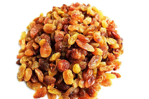 Beyaz arka planda izole edilmiş sarı ve kahverengi kuru üzüm yığınları. Güneşli ve parlak.