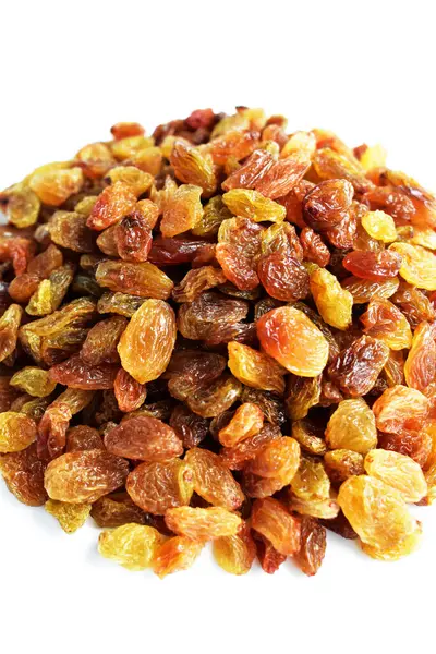 Beyaz arka planda izole edilmiş sarı ve kahverengi kuru üzüm yığınları. Güneşli ve parlak.