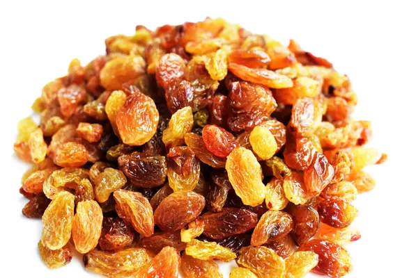 Beyaz arka planda izole edilmiş sarı ve kahverengi kuru üzüm yığınları. Güneşli ve parlak.