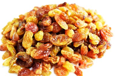 Beyaz arka planda izole edilmiş sarı ve kahverengi kuru üzüm yığınları. Güneşli ve parlak.