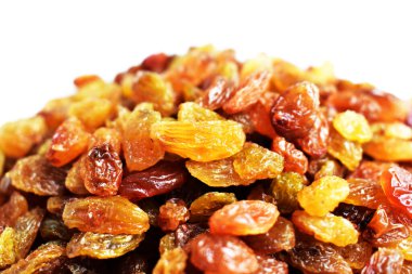 Beyaz arka planda izole edilmiş sarı ve kahverengi kuru üzüm yığınları. Güneşli ve parlak.