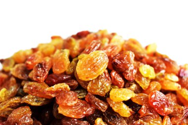 Beyaz arka planda izole edilmiş sarı ve kahverengi kuru üzüm yığınları. Güneşli ve parlak.