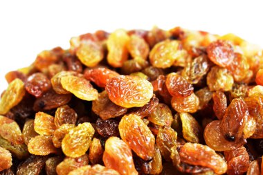 Beyaz arka planda izole edilmiş sarı ve kahverengi kuru üzüm yığınları. Güneşli ve parlak.