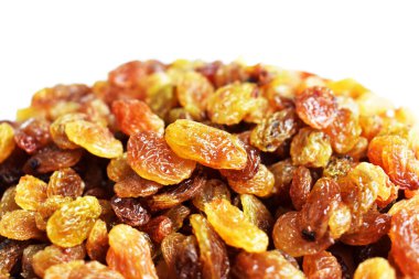 Beyaz arka planda izole edilmiş sarı ve kahverengi kuru üzüm yığınları. Güneşli ve parlak.