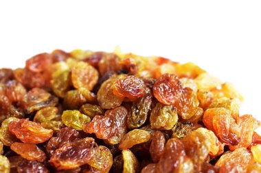 Beyaz arka planda izole edilmiş sarı ve kahverengi kuru üzüm yığınları. Güneşli ve parlak.