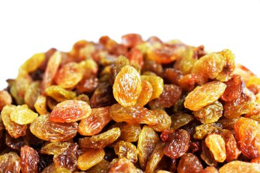 Beyaz arka planda izole edilmiş sarı ve kahverengi kuru üzüm yığınları. Güneşli ve parlak.