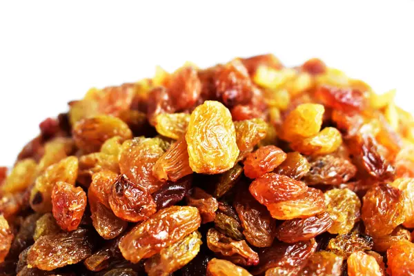 Beyaz arka planda izole edilmiş sarı ve kahverengi kuru üzüm yığınları. Güneşli ve parlak.