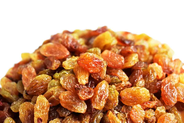 Beyaz arka planda izole edilmiş sarı ve kahverengi kuru üzüm yığınları. Güneşli ve parlak.