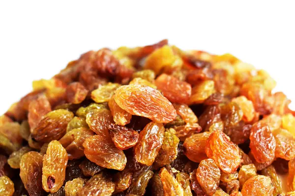 Beyaz arka planda izole edilmiş sarı ve kahverengi kuru üzüm yığınları. Güneşli ve parlak.