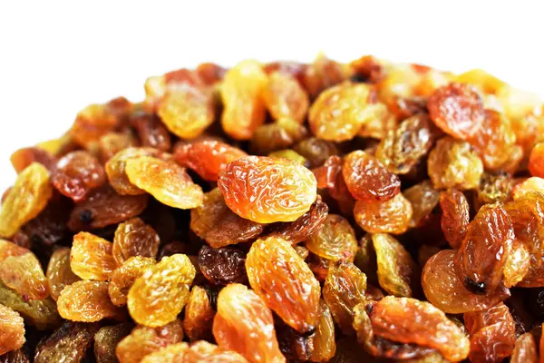 Beyaz arka planda izole edilmiş sarı ve kahverengi kuru üzüm yığınları. Güneşli ve parlak.