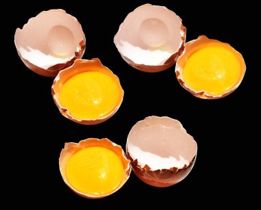 Kırpma yolu olan yumurta sarıları, siyah arka planda gölge yok, gerçek kahverengi yarım tavuk yumurtası.