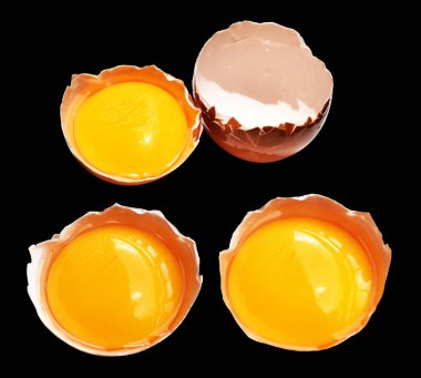 Kırpma yolu olan yumurta sarıları, siyah arka planda gölge yok, gerçek kahverengi yarım tavuk yumurtası.