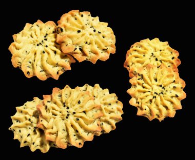 Pipolu tereyağlı kurabiyeler. Rosette şeklinde, kırpma yolu ile izole edilmiş. Siyah arkaplanda gölge yok.