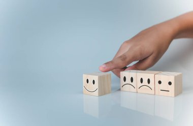 Mutlu gülümseme ikonunu elle seçmek. Geri bildirim derecesi ve olumlu müşteri değerlendirmesi, memnuniyet konsepti, memnuniyet anketi, zihinsel sağlık değerlendirmesi, dünya ruh sağlığı günü, pozitif düşünün.