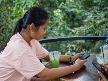 Woman staring at phone screen in coffee shop
