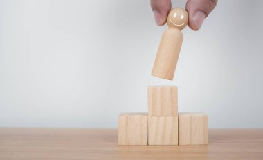 Liderlik ve takım lideri için iş dünyası ve insan kaynakları kavramı. Tahta bebeklerden biri öne çıkıyor. Farklı ve gruptan uzak duruyor.