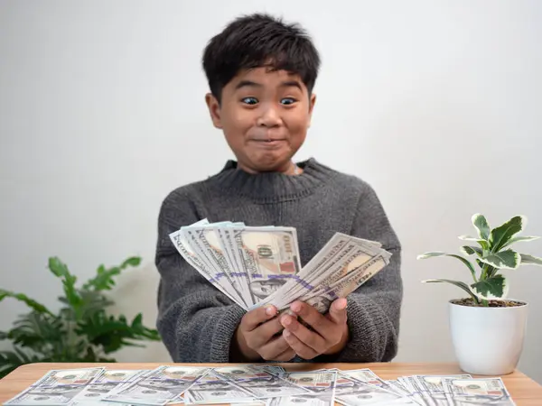 stock image The boy joyfully holds the money. Money saving concept, investment, finance.