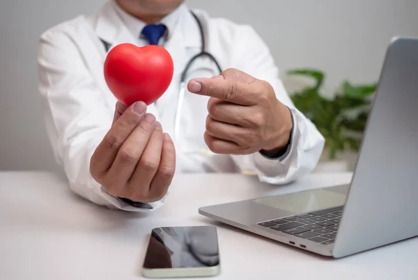 stock image A Doctor showing a red heart at hospital office. Medical health care and doctor staff service concept.
