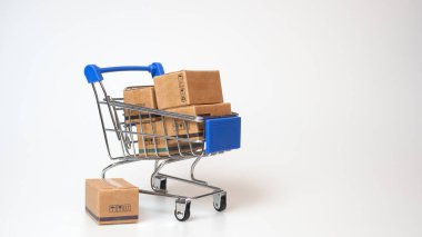 Alışveriş konsepti. Beyaz arka planda mavi alışveriş arabasında karton kutular. Çevrimiçi alışveriş tüketicileri evden ve teslimat servisinden alışveriş yapabilirler. kopyalama alanı ile