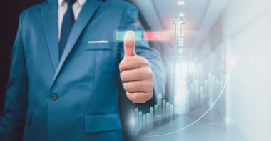 Borsa, iş büyümesi, ilerleme ya da başarı kavramı. İşadamı veya tüccar artan bir sanal hologram stoku gösteriyor, ticarete yatırım yap.