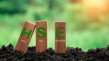 Tahta çubuklar HSE konsepti ile istiflenmiş doğa arka planında. HSE Sağlık Güvenliği Çevre Eğitimi Endüstrisi kavramı. İş ve organizasyon için sağlık güvenliği ortamı fikri.