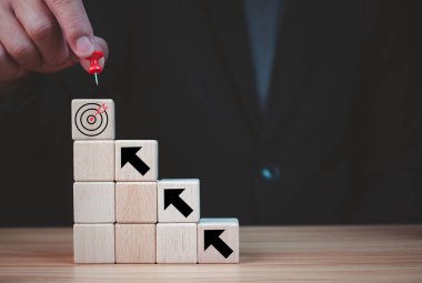 Hedef simgesini yazdıran tahta bloktaki hedef seçiminde işadamı rozeti. İş hedefleri ve hedef kavramı. İş rekabeti. iş stratejisi