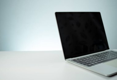 Bilgisayar görüntüsünün boş bir siyah ekranı var. Beyaz bir masaya yerleştirilmiş.