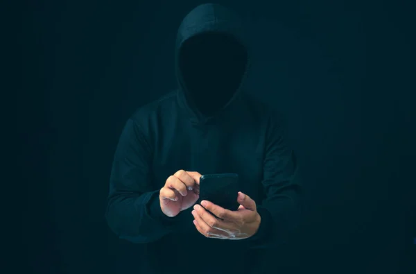Hackers work on phone in the dark. The concept of information security in the Internet network and information espionage. Virus attack. Hacker attack.