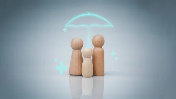 The concept of health insurance and Medical welfare. A family of wooden dolls with an umbrella and a plus sign on a white background represents protection, receiving benefits. health care planning
