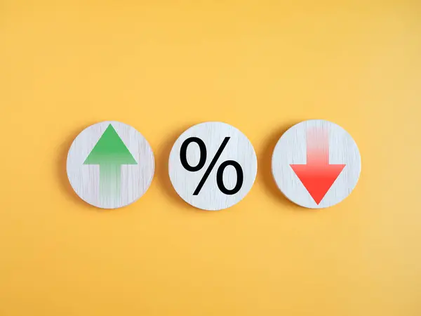 Interest rate financial and mortgage rates concept. Circle wood with icon percentage symbol and arrow up and down direction on yellow background.