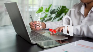 Girişte bilgisayar kullanan iş kadını, güvenli giriş dahil siber güvenlik ve veri güvenliği kavramını temsil ediyor.