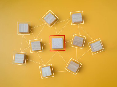 Sarı arka planda birbirine bağlı ahşap bloklar, kurumların ve iş ağlarının iletişim ve bağlantı konseptini temsil eder..