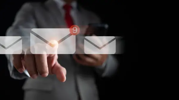 Businessman hand touching email on virtual screen. New email notification concept for business email communication and digital marketing. The inbox receives electronic message notifications.