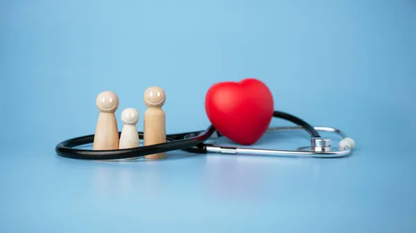 健康保険 医療福祉 木製の人形 赤心の青い背景 健康保険 医療へのアクセスに関するコンセプト — ストック写真