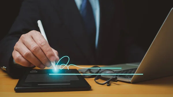 İşadamı elektronik e-imza, veri tablosu belge yönetimi, elektronik imza ve kağıtsız ofis kavramında elektronik kalem imzası kullanıyor.