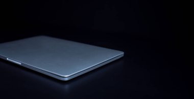 Koyu arkaplandaki beyaz bilgisayar, çevrimiçi veri ağı teknolojisi kullanılarak iş, finans ve hizmet bilgilerinin transferini temsil eder..