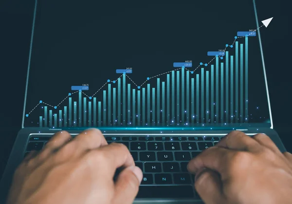 Human hand taps his finger on his computer to display a graph with growth for the future plan of organization. finance, management, plan, strategy.