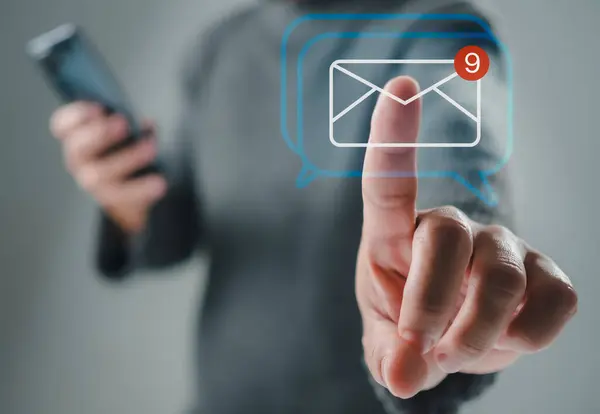 Human hand touching email on virtual screen. New email notification concept for business email communication and digital marketing. The inbox receives electronic message notifications. internet technology