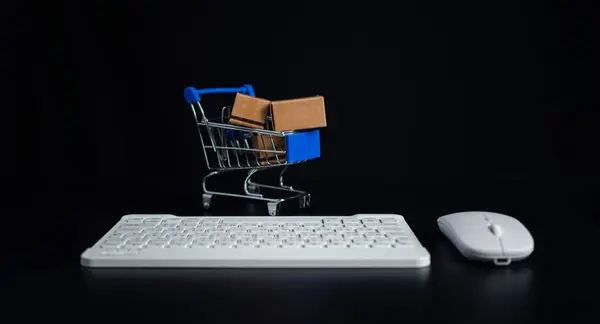 Boxes in a shopping car and keyboard on dark background. Ideas about online shopping, Online shopping for electronic commerce, Allows consumers to directly buy goods from seller over the internet.