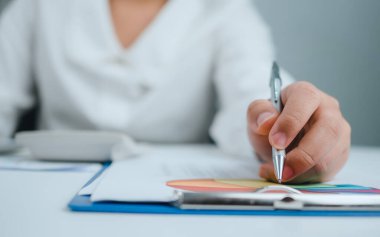 İş kadını insanlar şirket bilgilerini analiz etmek ve yönetmek için bilgisayar ve kağıt dökümanları kullanır. Düzenli performansı artırmak için grafikler, göstergeler ve KPI 'lerle iş analizi.