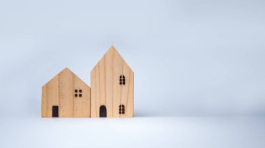 Beyaz arka planda ahşap evler, emlak, kiralama ve emlak yatırımları konsepti, birbirinin önüne yerleştiriliyor..