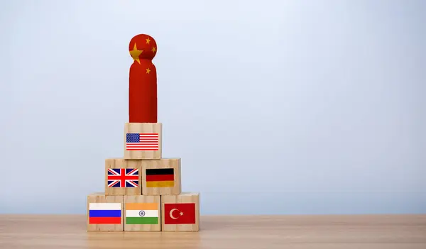 stock image Chinese flag screen printed on wooden dolls and other countries' flags on a wooden cube Show trade competition and tariff barriers. Trade war between the United States and China, Global trade competition.