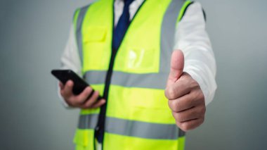 Başparmaklar yukarı. Başarılı ve mutlu bir mimar bulanık arka plana karşı duruyor. İnşaat mimarisini destekleyen tasarımcılar. Ev inşaatını mimarlar ya da mühendisler denetliyor..